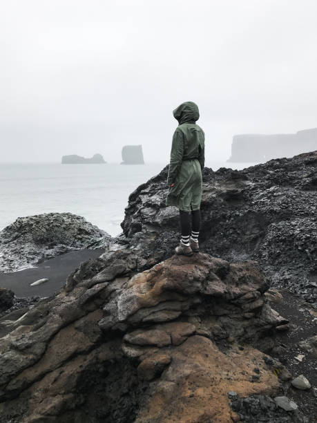 istock Wanderlust explorer discovering icelandic natural wonders. Basalt rock on black sand beach as known as Reynisfjara beach in the south coast of Iceland in fog and cloudy day. 1127908892