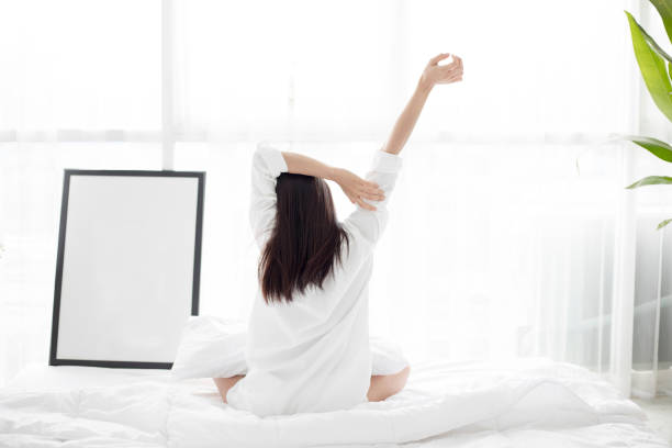 istock Woman Stretching Hands On Bed 1127909473
