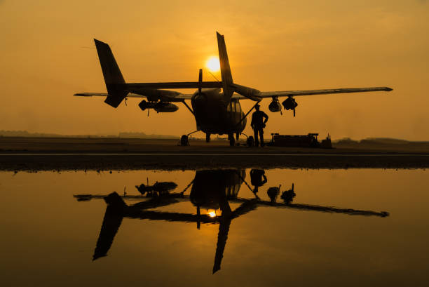 istock Silhouette airplane on landing with beautiful sun sky background 1127909635