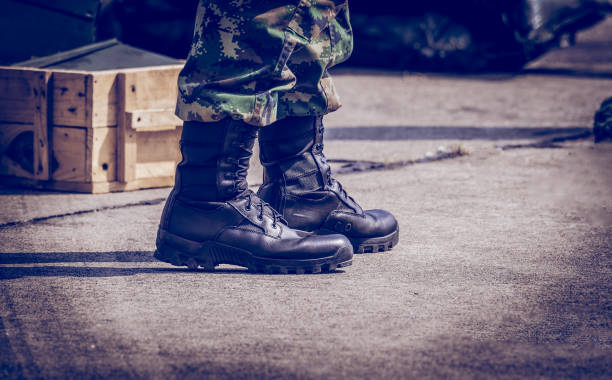 istock Close up soldier  leather combat shoes step on ground in army recruit  training 1127909828