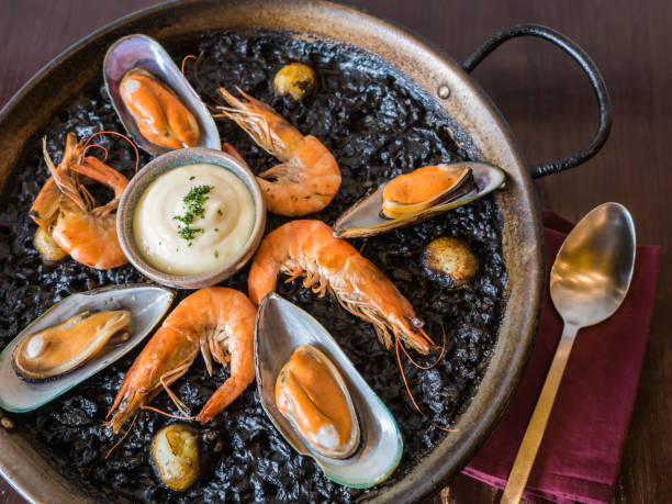 Black rice and seafood with alioli garlic mayonnaise stock photo