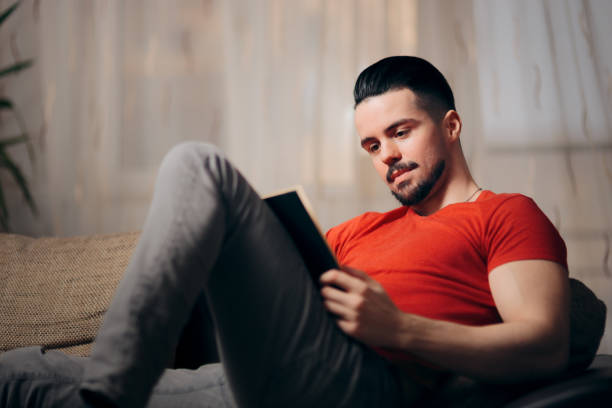 istock Handsome Man Reading a Book at Home and Relaxing 1127912675