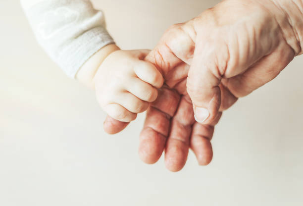 istock An old woman and a kid holding hands together 1127916259