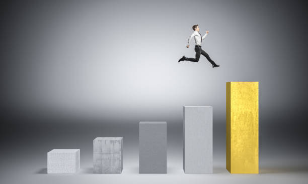 istock Full Length Of Man Jumping Over Bar Graph Against Gray Background 1127916569