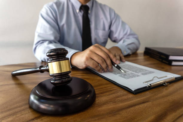 istock Midsection Of Lawyer Reading Document On Wooden Desk While Sitting In Office 1127920980