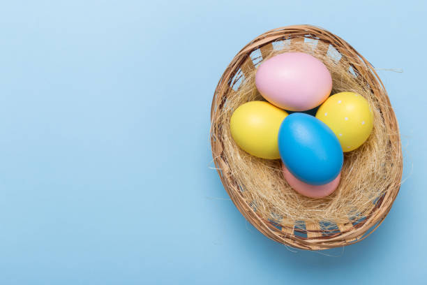 istock Colorfull easter eggs in nest on blue pastel color background with space. 1127923970