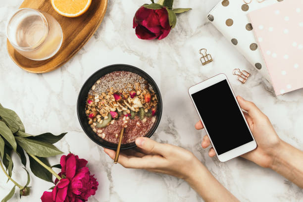 istock Flatlay of woman's hands with notebook and smartphone, vegan smoothie bowl with chia pudding 1127924831