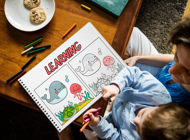 istock Young boy working on drawing pad network graphic overlay with parent 1127927904