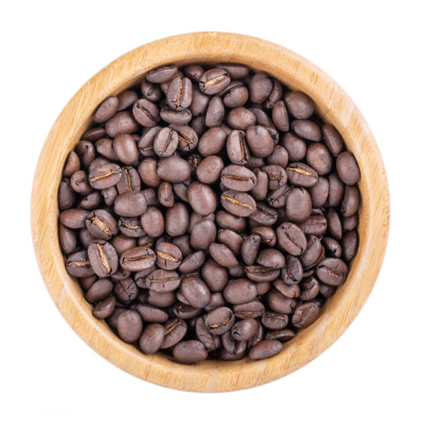istock Coffee beans in wooden bowl isolated on white. Top view. 1127932771