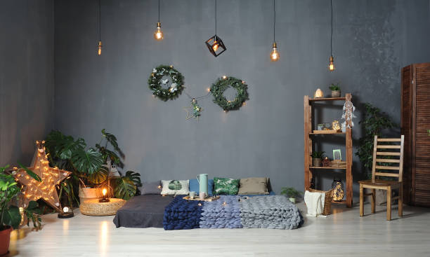 istock Beautiful Loft decor in a studio against a gray wall. Low bed with plaids, wooden shelving, chair, garlands 1127932876