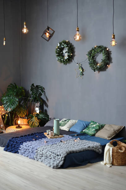 istock Beautiful Loft decor in the Studio against a gray wall. Low bed with plaids, garlands 1127934764