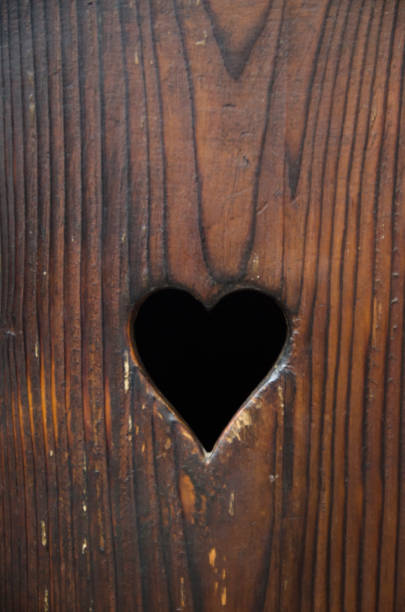 istock Heart shaped hole in a wooden door 1127934821
