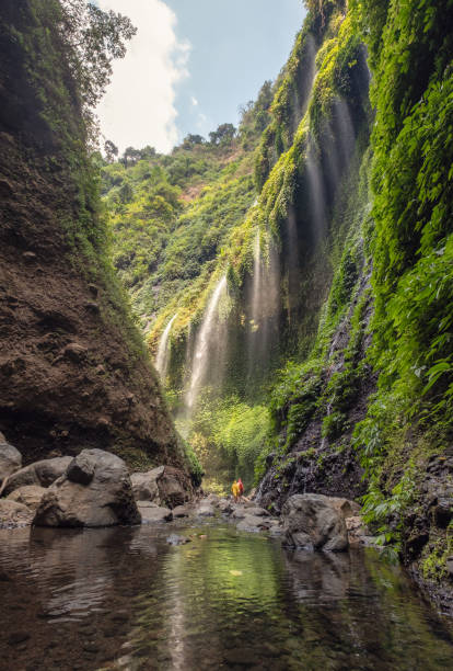 istock Beautiful Madakaripura waterfall flowing in rocky valley 1127938501