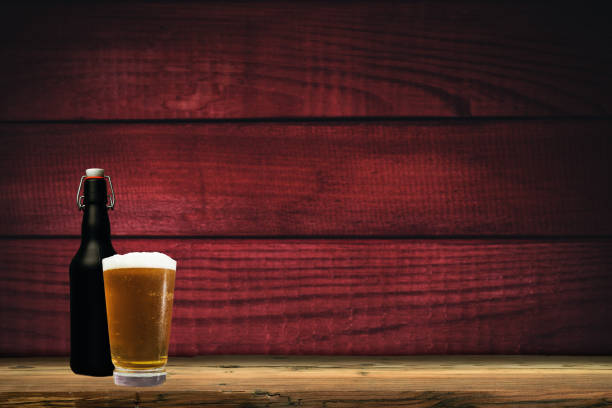 istock Glass of beer on a old oak table and background 1127939785