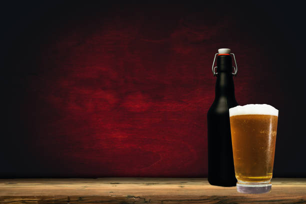 istock Glass of beer on a old oak table and background 1127940753