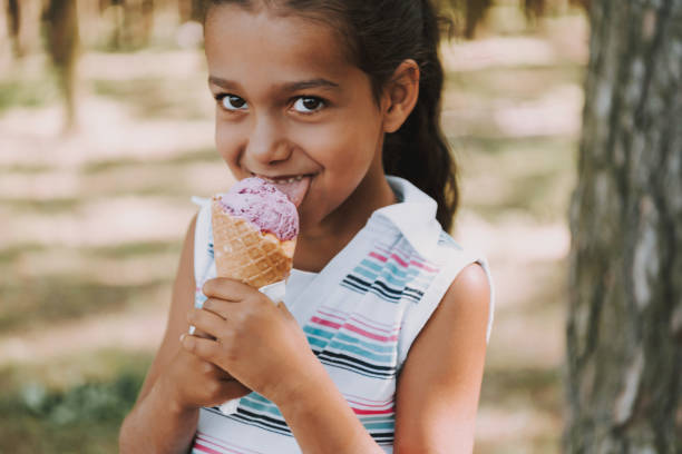 istock Young Satisfied Girl Eats Ice Cream In Forest. 1127942967