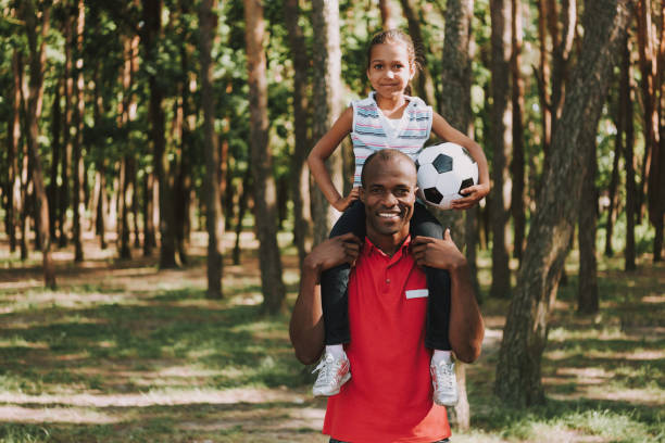 istock Daughter Sits On Fathers Shoulders With Ball. 1127942973