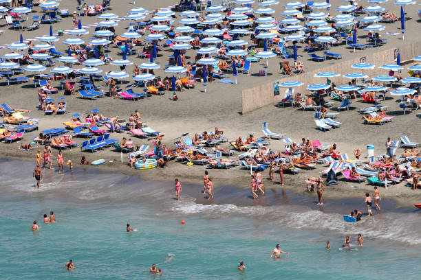 hundreds of tourists enjoy the summer along the ostia lido beach on the tyrrhenian coast of rome in italy - rome cityscape aerial view city imagens e fotografias de stock