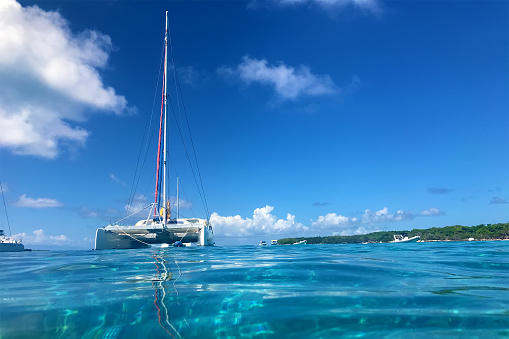 Swimming in  clear turquoise water near a catamaran, blue sky background , Petite terre, Guadeloupe, French West Indies.