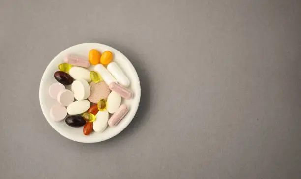 Pills on the plate and free space for your text. Grey paper background.