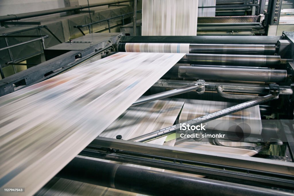 Printing newspapers Newspapers being printed in printing press. Newspaper Stock Photo