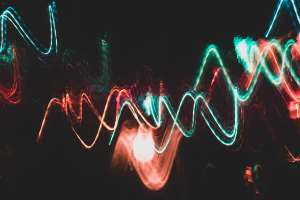 istock Colorful red and turquoise glowing wavy lines on black backdrop. 1127947892