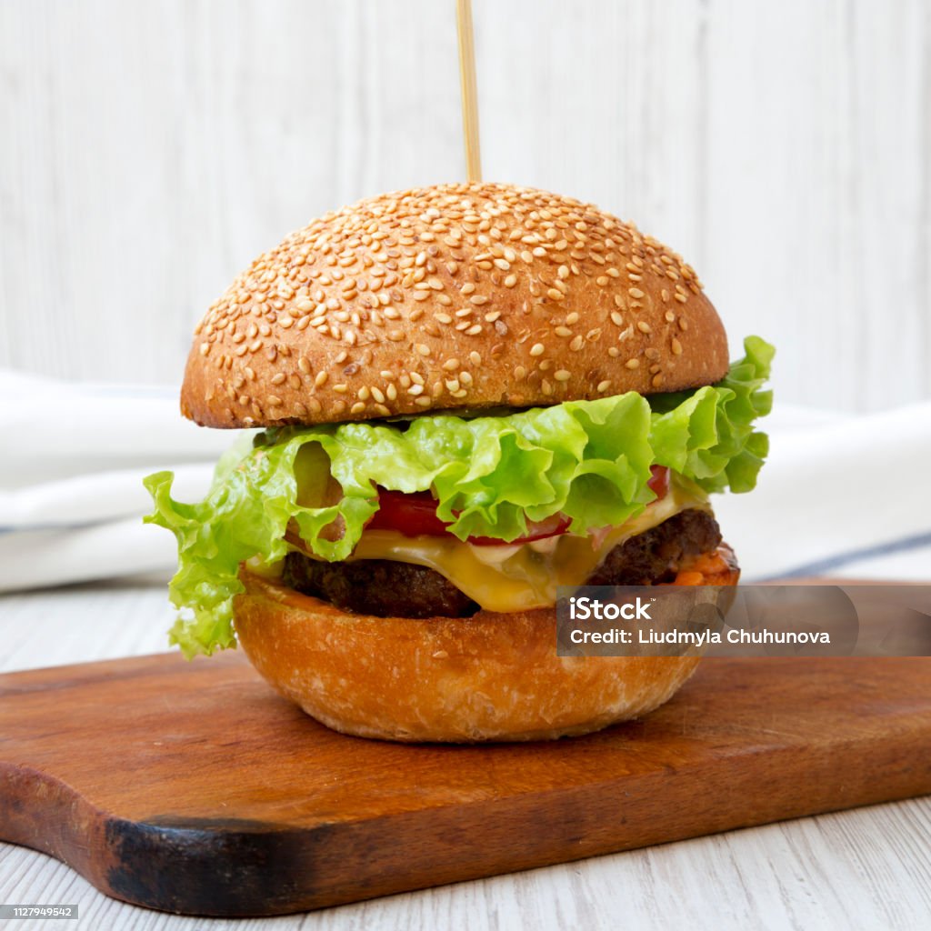 Burger Keju Buatan Sendiri Di Atas Papan Kayu Pedesaan Di Atas Latar Belakang Kayu Putih Burger Keju Buatan Sendiri Di Atas Papan Kayu Pedesaan Di Atas Latar Belakang Kayu Putih