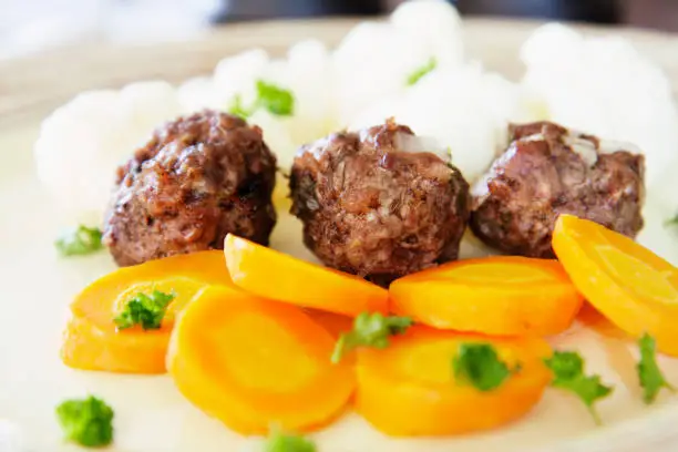 Healthy eating, Hay diet, low carb diet recipe - small beef meatballs baked in the oven and served with boiled carrots and cauliflower.