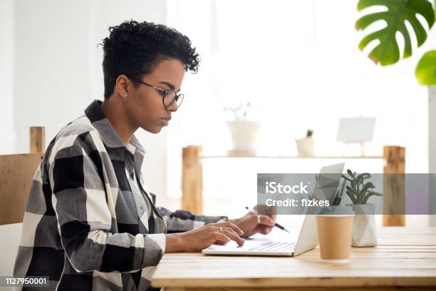 African American Young Woman Using Laptop Working Or Studying Online Stock Photo - Download Image Now
