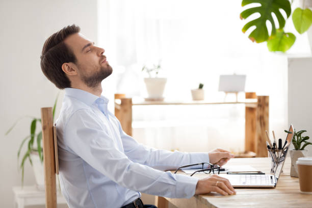 Calm businessman taking break to relax finished work in office