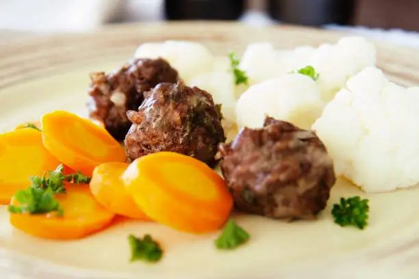 Healthy eating, Hay diet, low carb diet recipe - small beef meatballs baked in the oven and served with boiled carrots and cauliflower.