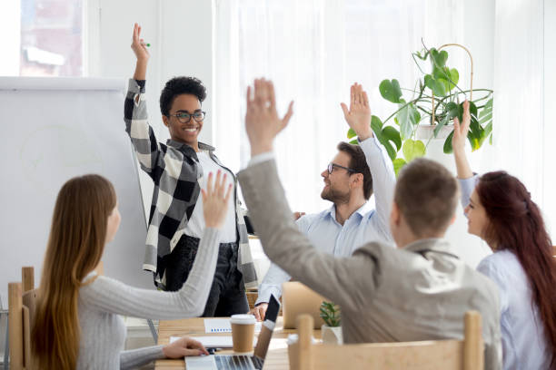 istock Diverse business people group raise hands at corporate presentation training 1127950022
