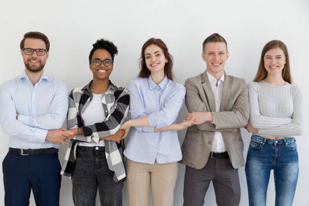 istock Happy multi-ethnic team people holding hands standing in row 1127950062