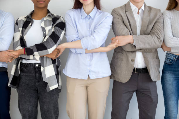 istock Diverse business people group standing holding hands, close up view 1127950070