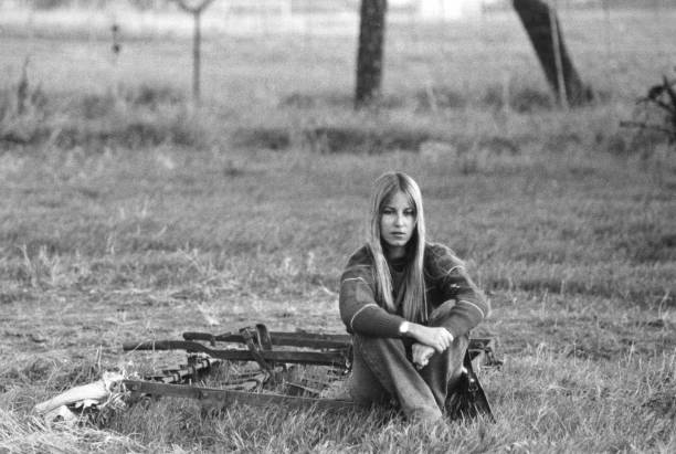 junge frau sitzt in einem park. 1970. - 1970 stock-fotos und bilder