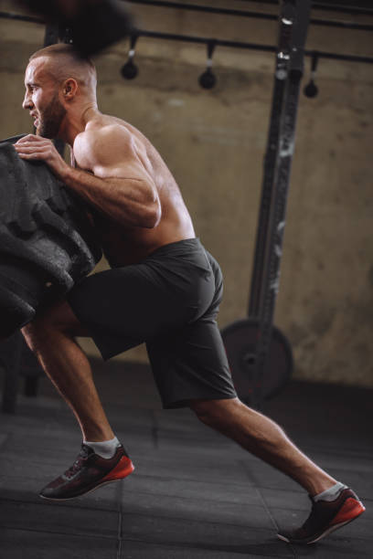 istock a fit male athlete is working out with a huge tire 1127955911