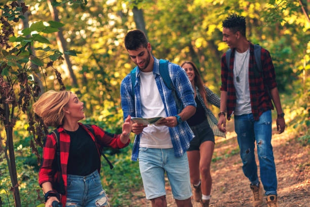 istock Group of four friends hiking through forest together. 1127956089