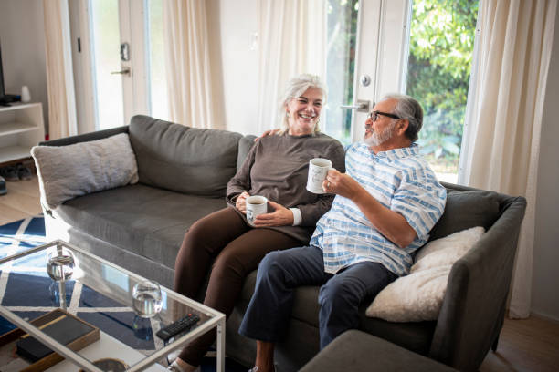 istock Senior couple sitting on the sofa and drinking tea 1127957438