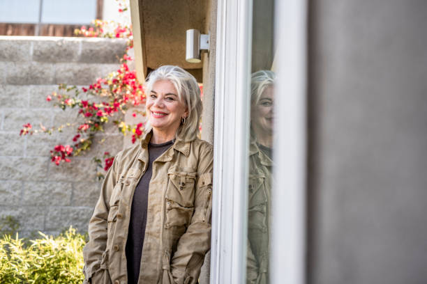 istock Senior woman standing outside and smiling 1127957483