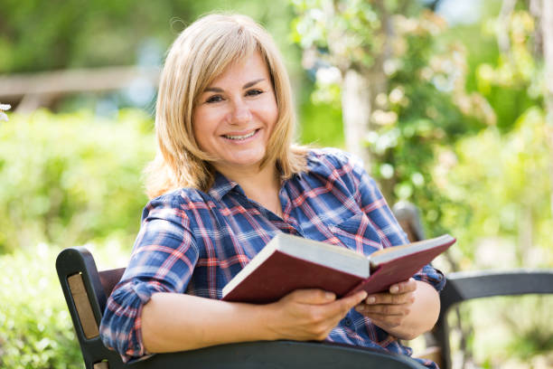 istock mature woman book 1127958210