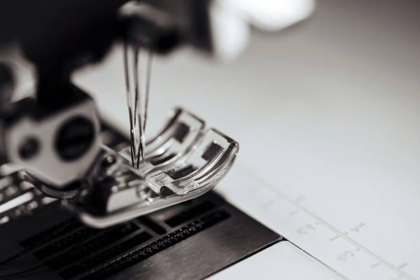 fragment of the mechanism of the sewing machine with a needle closeup of monochrome tone