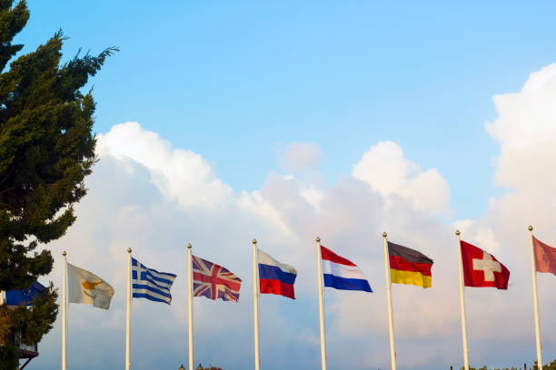 banderas de diferentes países aleteo viento contra el cielo azul - british empire flag global uk fotografías e imágenes de stock