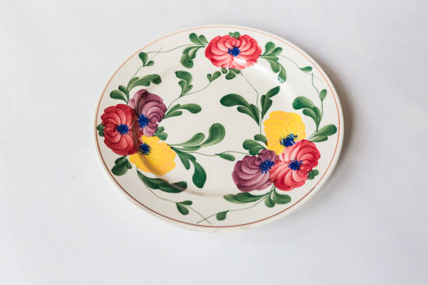 istock a white round plate with floral and line pattern on white background 1127963634