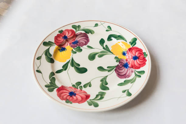 istock a white round plate with floral and line pattern on white background 1127963720