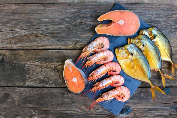 istock Different seafood: fish, shrimp on wooden old background. Top view. Flat lay. 1127964354