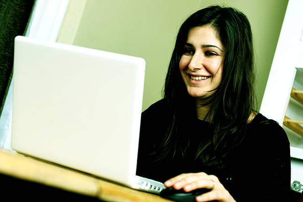 istock Dark haired woman happy at white laptop computer 112796541