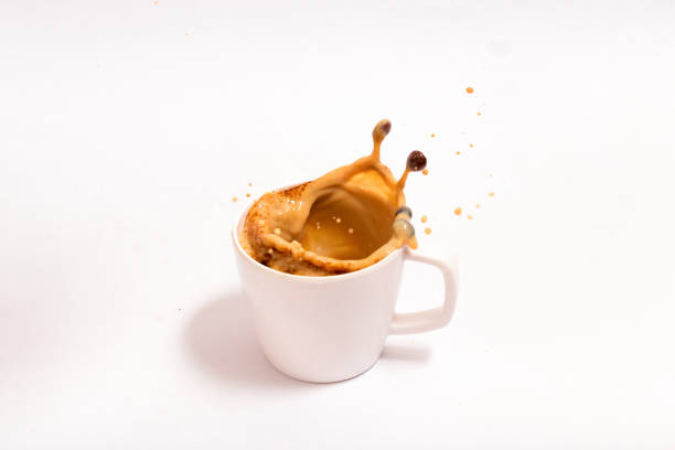 istock Cup of splashing hot coffee on white background 1127969570