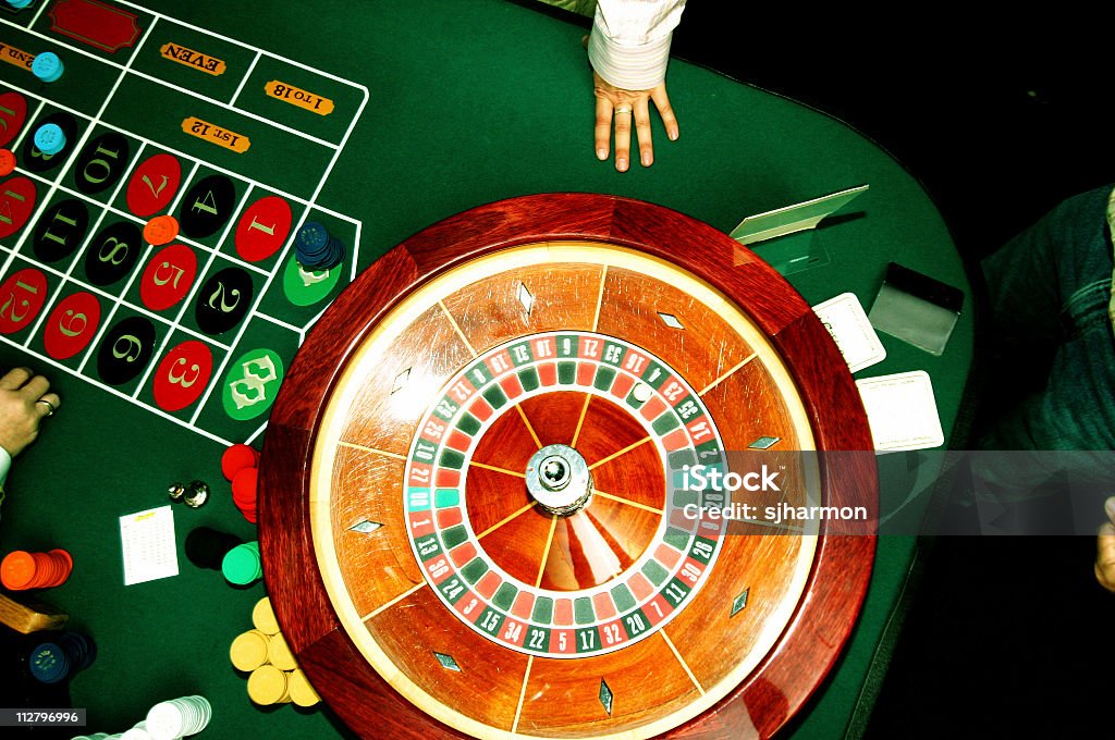 Roulette wheel with hand and table Roulette wheel with hand and table in casino with chips, bets, and cross processed Grand Casino - Monte Carlo Stock Photo
