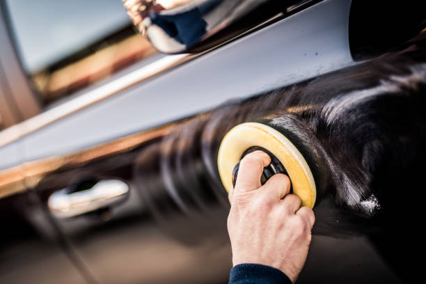 dojrzały mężczyzna polerowanie samochodu z aplikatora pad - polishing car zdjęcia i obrazy z banku zdjęć