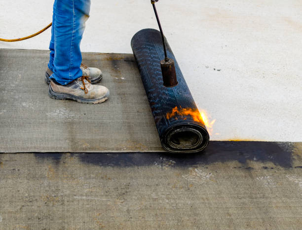 istock Worker preparing part of bitumen roofing felt roll for melting by gas heater torch flame. 1127970879